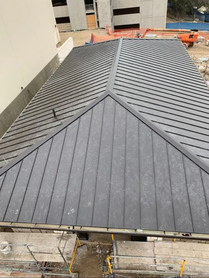 Commercial metal roof construction with crane equipment in Freeport